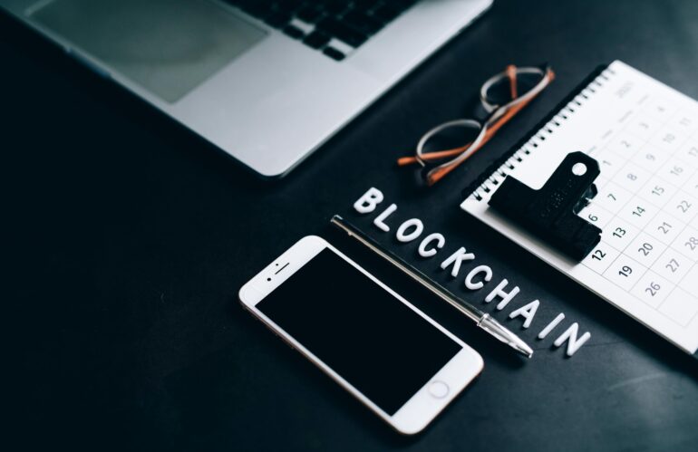 Free Flat lay of a modern digital workspace with blockchain theme, featuring a smartphone and calendar. Stock Photo