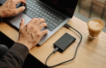 A man sitting at a table using a laptop computer